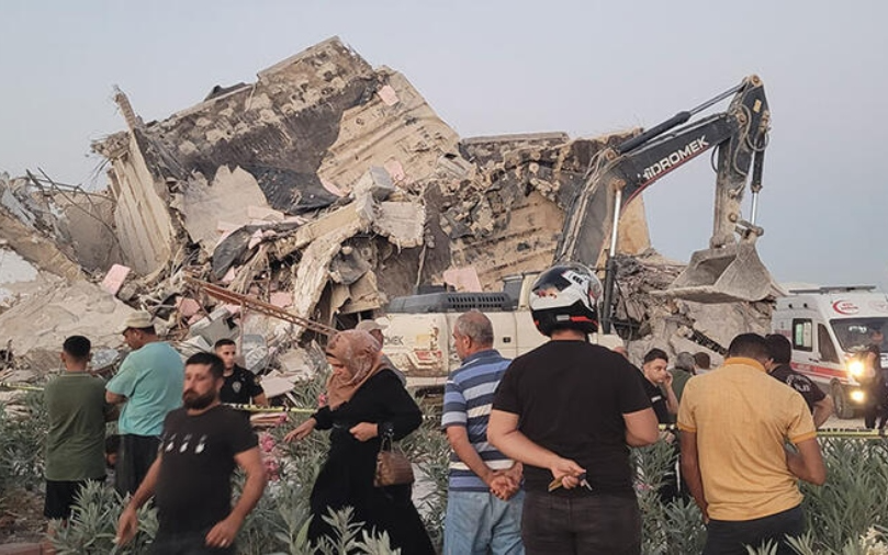 Hatay’da hasarlı bina yıkım sırasında iş makinesinin üstüne devrildi